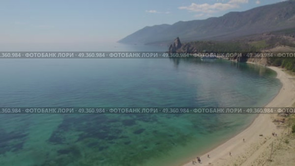 Sandy bay on a summer day. Beautiful view of Cape Kolokolny, sandy beach, clear water of Lake Baikal. Drone flight over sandy beach. Стоковое видео, видеограф Виктория Тельминова / Фотобанк Лори