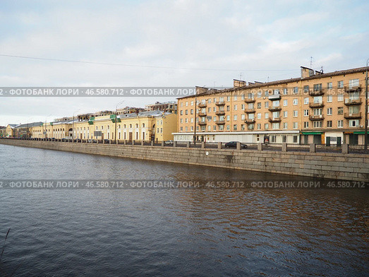 Sankt-Petersburg, Russia 01.19.25: A serene view of a river Obvodny Canal reflecting soft light of late afternoon. Historical buildings line waterfront, showcasing architectural details and city life. Редакционное фото, фотограф Юлия Петровская / Фотобанк Лори