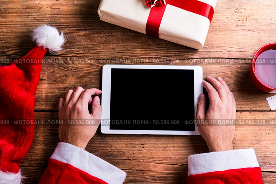 Santa Claus holding tablet in his hands. Santa Claus with tablet. Стоковое фото, агентство Ingram Publishing / Фотобанк Лори