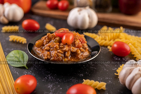 Sauce for stir-frying spaghetti or stir-frying macaroni on a black plate. Стоковое фото, агентство Ingram Publishing / Фотобанк Лори