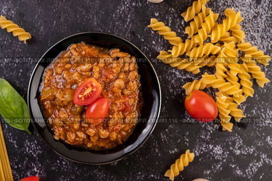 Sauce for stir-frying spaghetti or stir-frying macaroni on a black plate. Стоковое фото, агентство Ingram Publishing / Фотобанк Лори