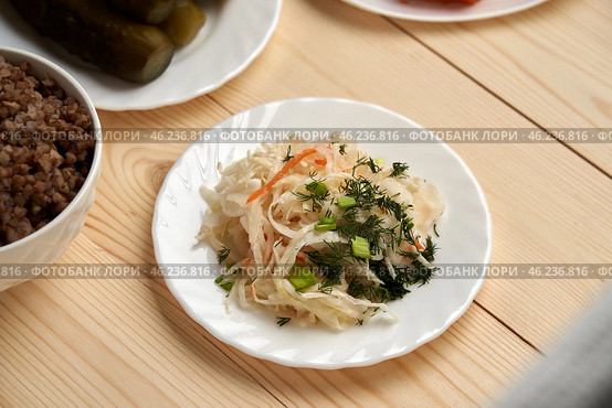 sauerkraut cabbage on a wooden background symbolizes a quiet conversation with God, which occurs through a prayer and reading a word during fasting. Стоковое фото, фотограф Скрипачев Антон / Фотобанк Лори