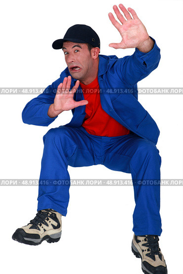 Scared plumber shielding face. Стоковое фото, агентство Ingram Publishing / Фотобанк Лори