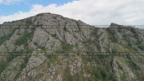 Scenic landscape featuring steep mountains and dense forests in a valley, with dramatic cloud formations above, highlighting the tranquility of the natural environment. Стоковое видео, видеограф Ирина Ручушкина / Фотобанк Лори