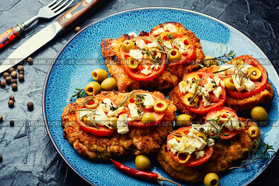 Schnitzel, breaded and fried thin layer of meat. Austrian dish. Schnitzel with olives and tomato. Стоковое фото, агентство Ingram Publishing / Фотобанк Лори