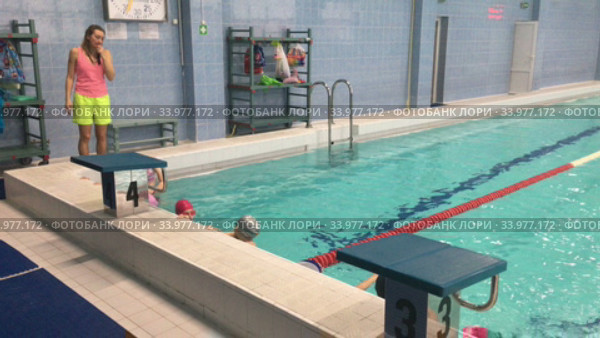 School age kids are ready to do their exercise in pool. Young children swimming training. Russian swimming youth sports school of Olympic reserve. Стоковое видео, видеограф Кекяляйнен Андрей / Фотобанк Лори