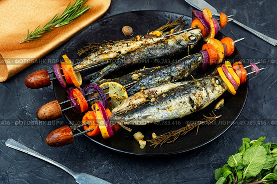 Seafood platter with sardines kebab, grilled fish.. Fish and vegetable skewer in barbecue grill. Стоковое фото, агентство Ingram Publishing / Фотобанк Лори
