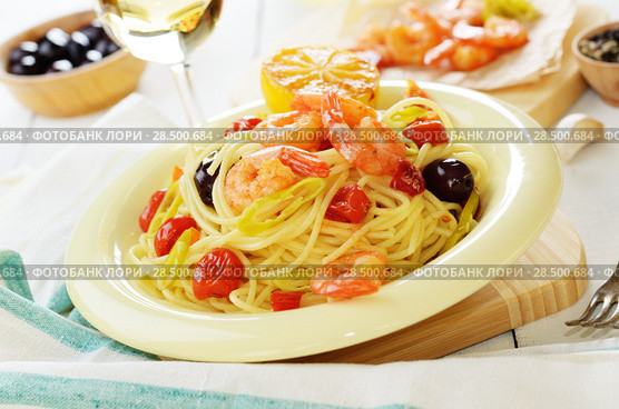 Seafood spaghetti pasta dish with shrimps and cherry tomatoes served with white wine. Стоковое фото, агентство Ingram Publishing / Фотобанк Лори