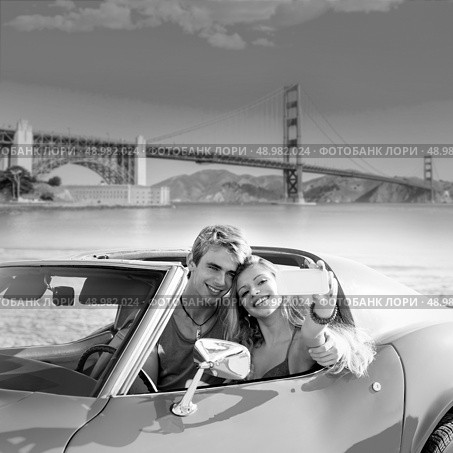selfie of young teen couple at convertible car in San Francisco Golden Gate Bridge photo mount. Стоковое фото, агентство Ingram Publishing / Фотобанк Лори