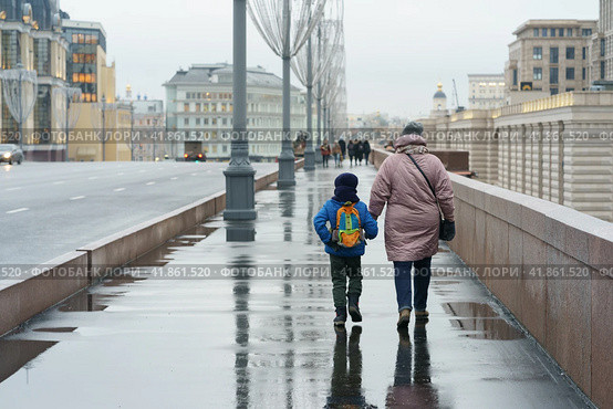 Семья идет по мокрой улице Москвы в дождливый день (2019 год). Стоковое фото, фотограф YuryKara / Фотобанк Лори