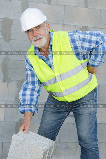senior builder suffering from back pain. Стоковое фото, агентство Ingram Publishing / Фотобанк Лори