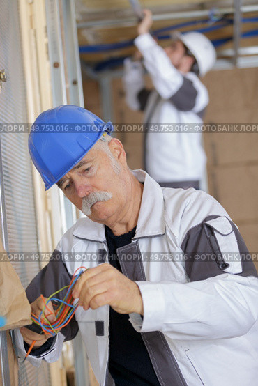 senior electrician concentrating on wiring. Стоковое фото, агентство Ingram Publishing / Фотобанк Лори