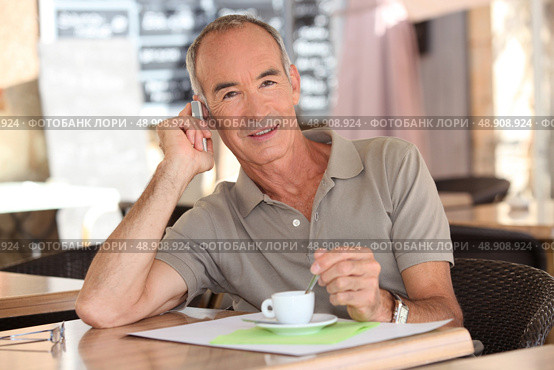 Senior having an expresso while talking on his cellphone. Стоковое фото, агентство Ingram Publishing / Фотобанк Лори