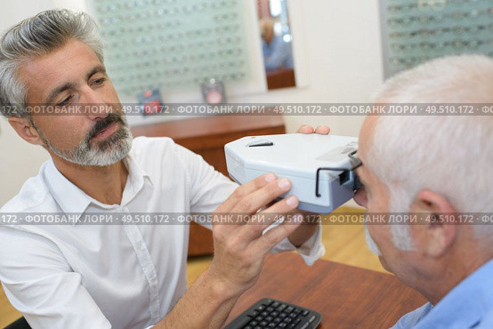 senior patient while sitting with optician in clinic. Стоковое фото, агентство Ingram Publishing / Фотобанк Лори