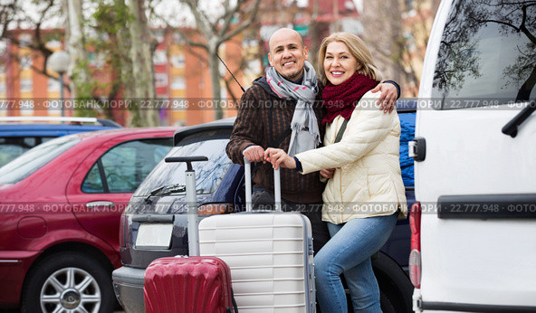 Senior smiling couple of travellers posing with trollers. Стоковое фото, фотограф Яков Филимонов / Фотобанк Лори