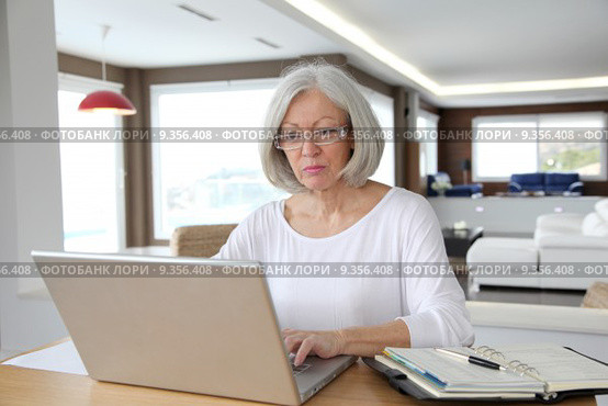 Senior woman at home in front of laptop computer. Стоковое фото, фотограф Fabrice Michaudeau / PantherMedia / Фотобанк Лори