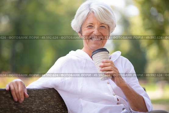 senior woman drinking take away coffee in the park. Стоковое фото, агентство Ingram Publishing / Фотобанк Лори