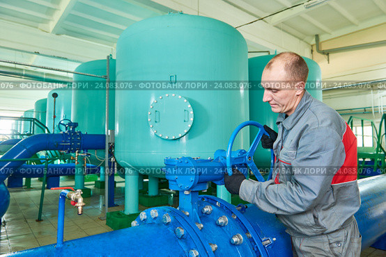 serviceman operating industrial water purification or filtration equipment. Стоковое фото, фотограф Дмитрий Калиновский / Фотобанк Лори