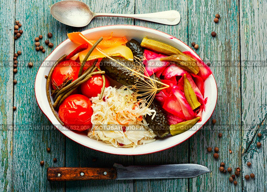 Set of pickles from tomato, sauerkraut, okra, cucumbers and cowpea. Pickles vegetable on wooden table. Homemade pickles, salty vegetables. Стоковое фото, агентство Ingram Publishing / Фотобанк Лори