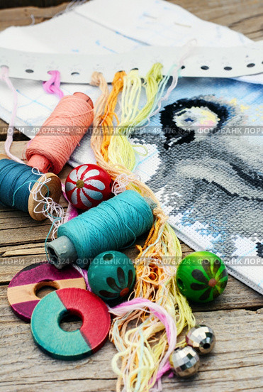 Set of threads for embroidery on background of handmade paintings. Parts and accessories embroidery. Стоковое фото, агентство Ingram Publishing / Фотобанк Лори