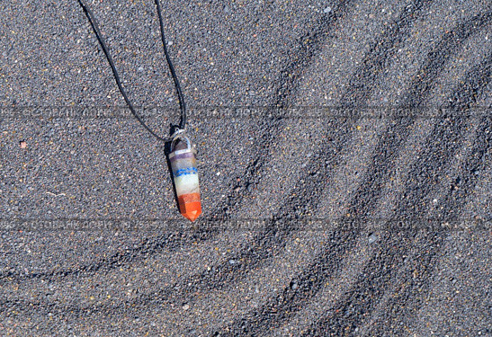 Seven chakras healing crystals pendulum. Witchcraft, herbal medicine and healing, Magic healing Rock for Reiki Crystal Ritual, Witchcraft, spiritual esoteric practice. Healing crystals pendulum on black sand background. Стоковое фото, агентство Ingram Publishing / Фотобанк Лори