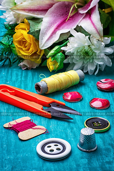 sewing accessories with bouquet of fresh flowers on turquoise background. Стоковое фото, агентство Ingram Publishing / Фотобанк Лори