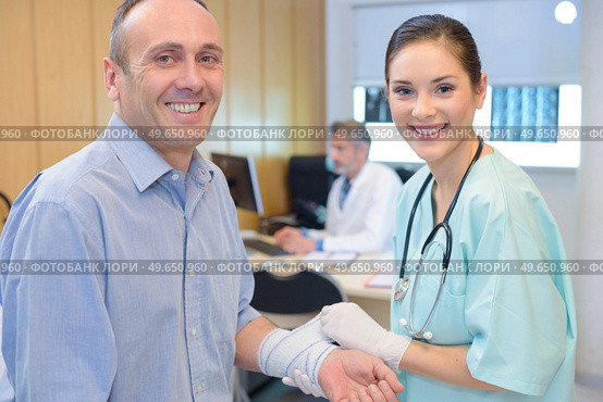 she is wrapping the fractured arm. Стоковое фото, агентство Ingram Publishing / Фотобанк Лори