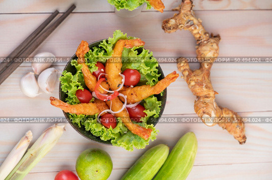 Shrimp deep fried batter placed on salad and tomatoes in a wooden bowl. Стоковое фото, агентство Ingram Publishing / Фотобанк Лори