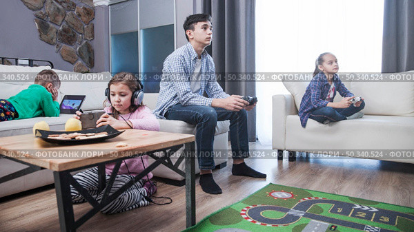 sibling playing video games living room. Стоковое фото, агентство Ingram Publishing / Фотобанк Лори