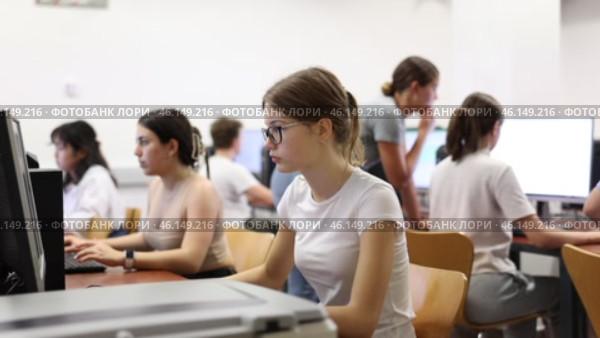 Side view on focused teenager female student sitting at desk in computer class, preparing for exam. Стоковое видео, видеограф Яков Филимонов / Фотобанк Лори