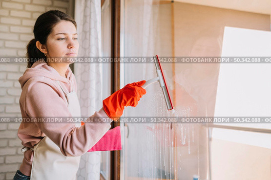 side view woman cleaning window. Стоковое фото, агентство Ingram Publishing / Фотобанк Лори