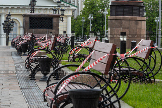 Скамейки перетянутые сигнальной лентой на Манежной площади города Москвы во время эпидемии коронавируса COVID-19 и режима самоизоляции в городе Москве, Россия (2020 год). Стоковое фото, фотограф Николай Винокуров / Фотобанк Лори