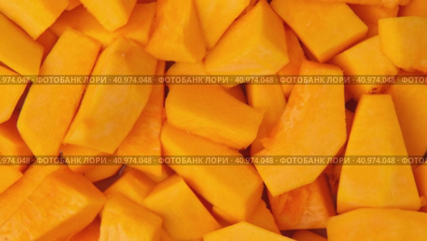Slices of fresh pumpkin chunks background. Yellow Juicy pieces of pumpkin. Texture close up. Turning, rotation. Full frame with copy space for text, label. Food backdrop. Bright orange sliced pumpkin. Стоковое видео, видеограф Марина Демидюк / Фотобанк Лори
