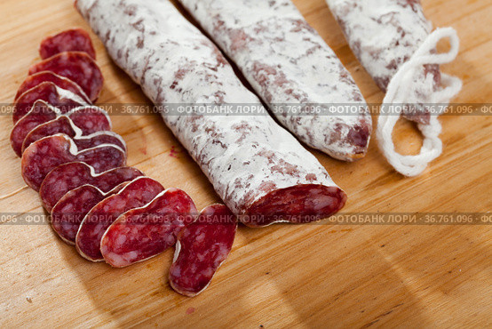 Slicing delicious Spanish smoked sausage fuete. Стоковое фото, фотограф Яков Филимонов / Фотобанк Лори