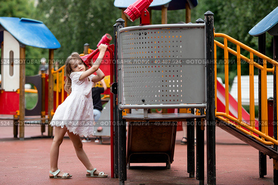 Small children play on the playground. A girl and a boy are having fun playing outside on a sunny spring day. Childhood and child development. Стоковое фото, фотограф Photojuli / Фотобанк Лори