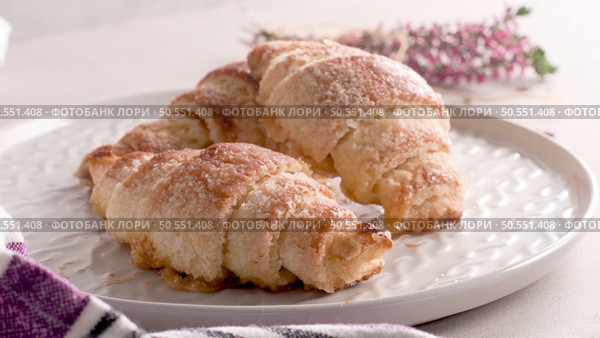 Small croissants in white ceramic plates, homemade cakes on concrete table top. Стоковое фото, агентство Ingram Publishing / Фотобанк Лори