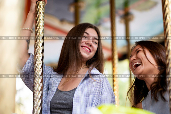 smiley female friends carousel. Стоковое фото, агентство Ingram Publishing / Фотобанк Лори