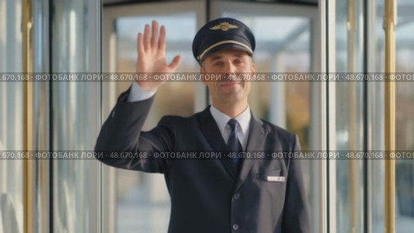 Smiling airline pilot waving hand in airport terminal. Стоковое AI-видео, аниматор Юрий Поздников / Фотобанк Лори