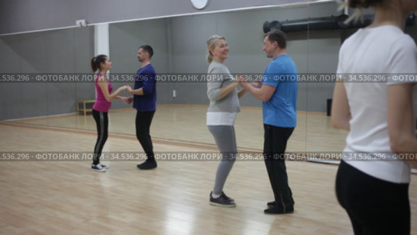 Smiling dancing people practicing bachata movements in dance studio for adults. Стоковое видео, видеограф Яков Филимонов / Фотобанк Лори