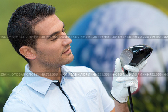 smiling golfer holding golf club. Стоковое фото, агентство Ingram Publishing / Фотобанк Лори
