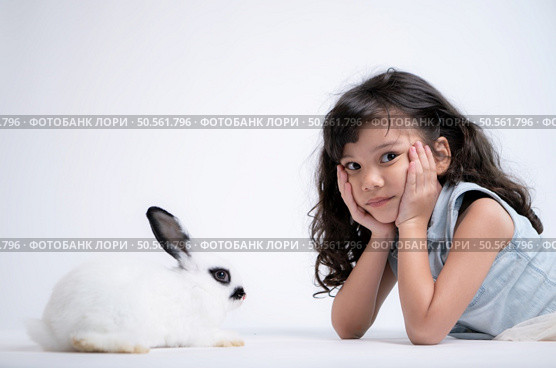 Smiling little girl and with their beloved rabbit, showcasing the beauty of friendship between humans and animals. Стоковое фото, агентство Ingram Publishing / Фотобанк Лори