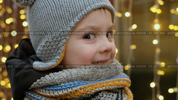 Smiling small child on background of golden garland at Christmas market in winter. Стоковое фото, фотограф Маргарита Кирьякова / Фотобанк Лори