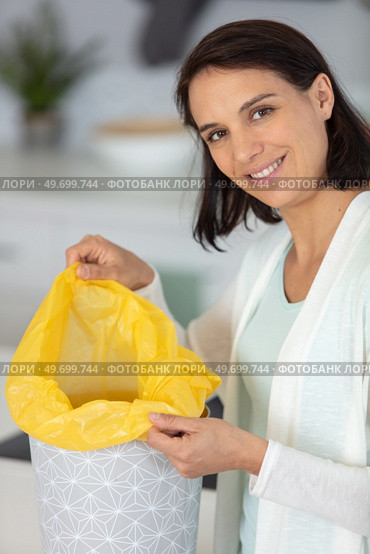 smiling woman changing garbage bags. Стоковое фото, агентство Ingram Publishing / Фотобанк Лори