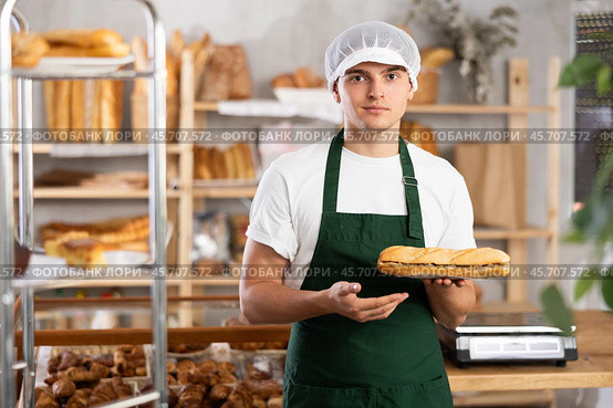 Smiling young bakery seller offering traditional Spanish bocadillo. Стоковое фото, фотограф Яков Филимонов / Фотобанк Лори