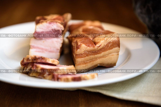 smoked pork ribs on white plate on wooden background. Стоковое фото, агентство Ingram Publishing / Фотобанк Лори