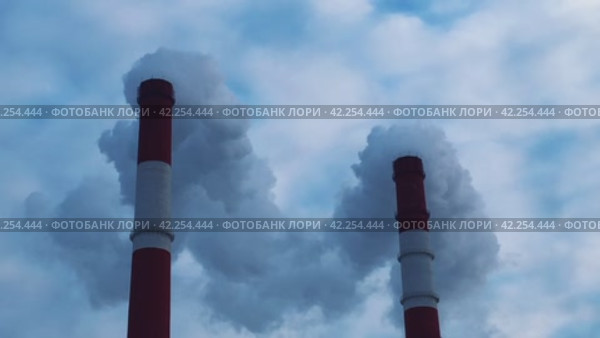 Smoky chimneys of a power plant against a cloudy sky. Стоковое видео, видеограф Ярославский Максим / Фотобанк Лори