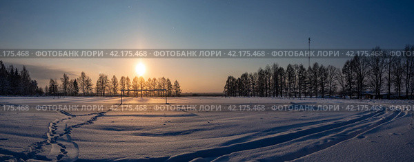 Снег искрится на заснеженном футбольном поле зимним вечером. Стоковое фото, фотограф Евгений Горбунов / Фотобанк Лори