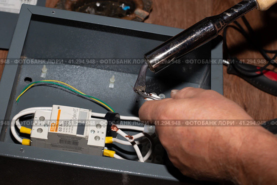 Soldering the elements of the electrical circuit of the modular contactor of the heating system of the cottage. Anapa, Russia-04.09.2021. Редакционное фото, фотограф Коханова Наталья / Фотобанк Лори