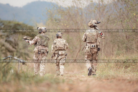 Soldiers in camouflage military uniforms carrying weapons, Reconnaissance missions in the tropical forest area, Assault infantry battle training. Стоковое фото, агентство Ingram Publishing / Фотобанк Лори