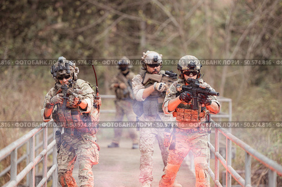 Soldiers in camouflage military uniforms carrying weapons, Reconnaissance missions in the tropical forest area, Assault infantry battle training. Стоковое фото, агентство Ingram Publishing / Фотобанк Лори